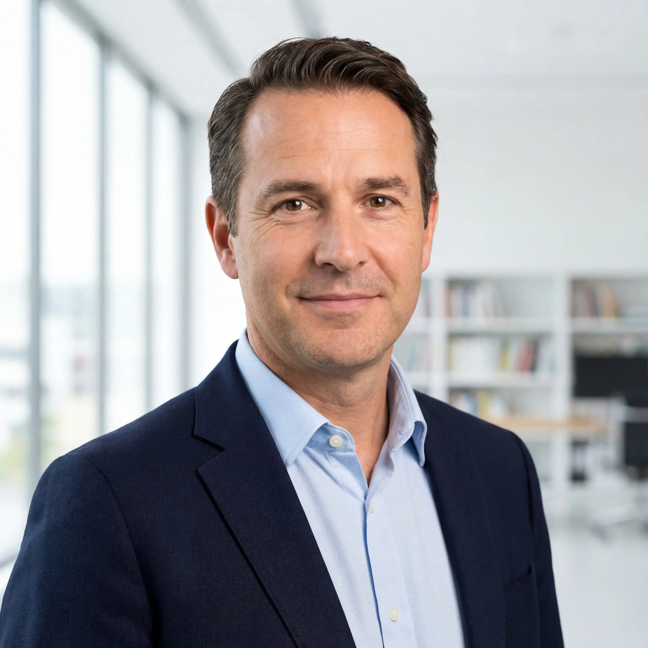 A professional executive in a suit standing in a modern office, representing leadership, trust, and business expertise.